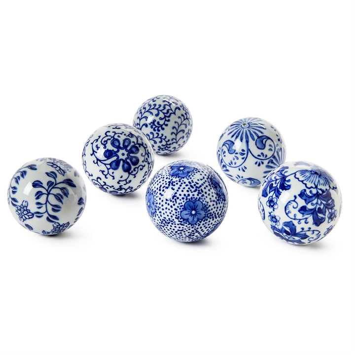 Set of six blue and white ceramic balls with floral patterns on a white background