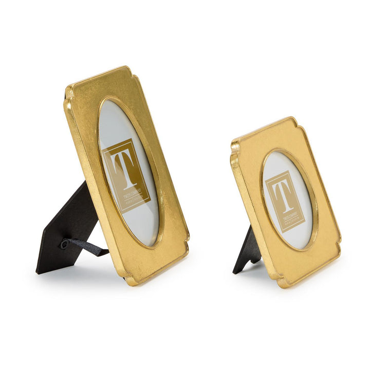 Two gold picture frames with black stands on a white background