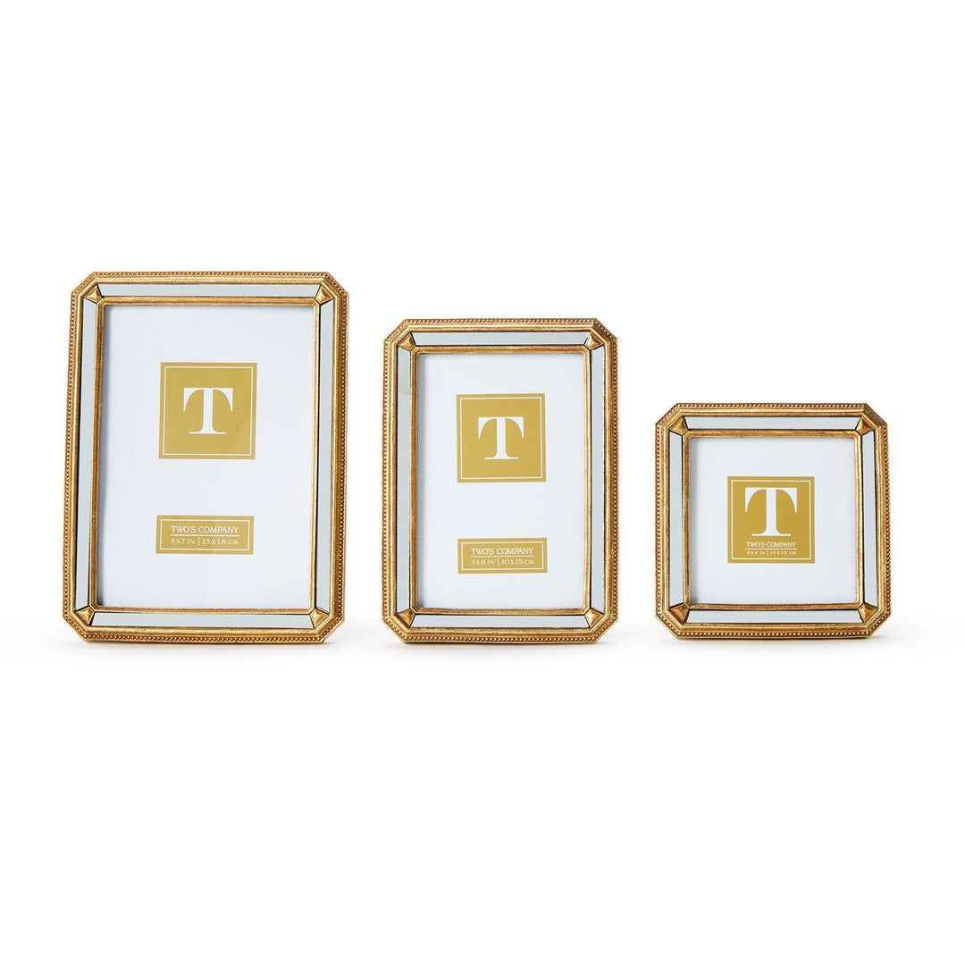 Three gold-framed picture frames with a central 'T' logo on a white background