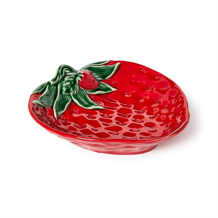 Red ceramic strawberry-shaped dish with green leaves on a white background