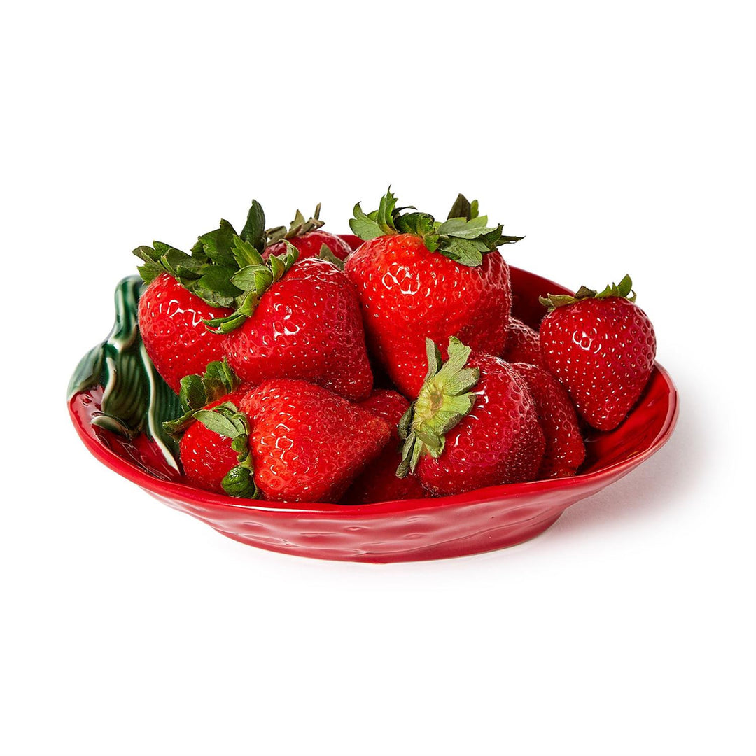 Red bowl filled with strawberries on a white background
