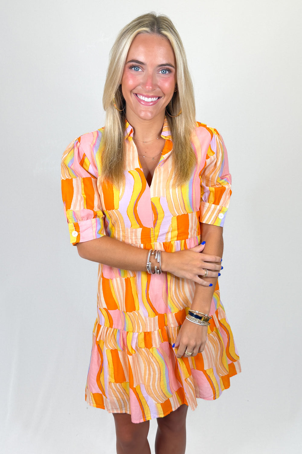 Woman wearing a colorful patterned dress on a white background