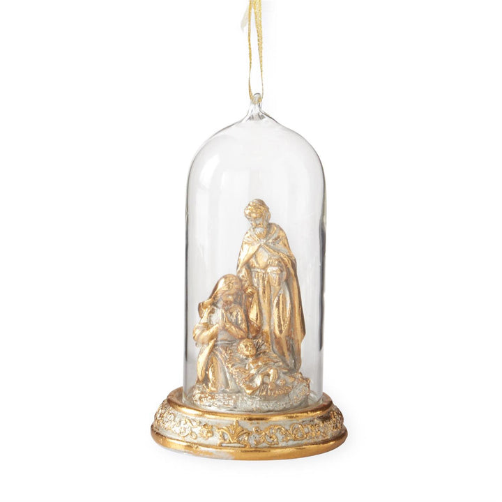 A decorative hanging ornament featuring a small gold-toned figurine of the Holy Family under a clear glass dome with an ornate gold base, suspended by a thin gold string against a white background.