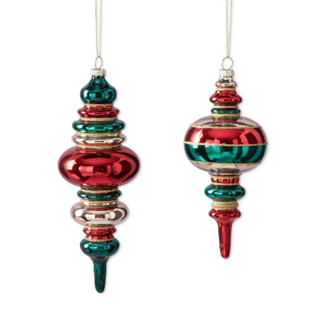 Two vintage-style Christmas glass ornaments hanging against a white background. One ornament is a pointed teardrop shape in glossy red and green glass with metallic gold trim.