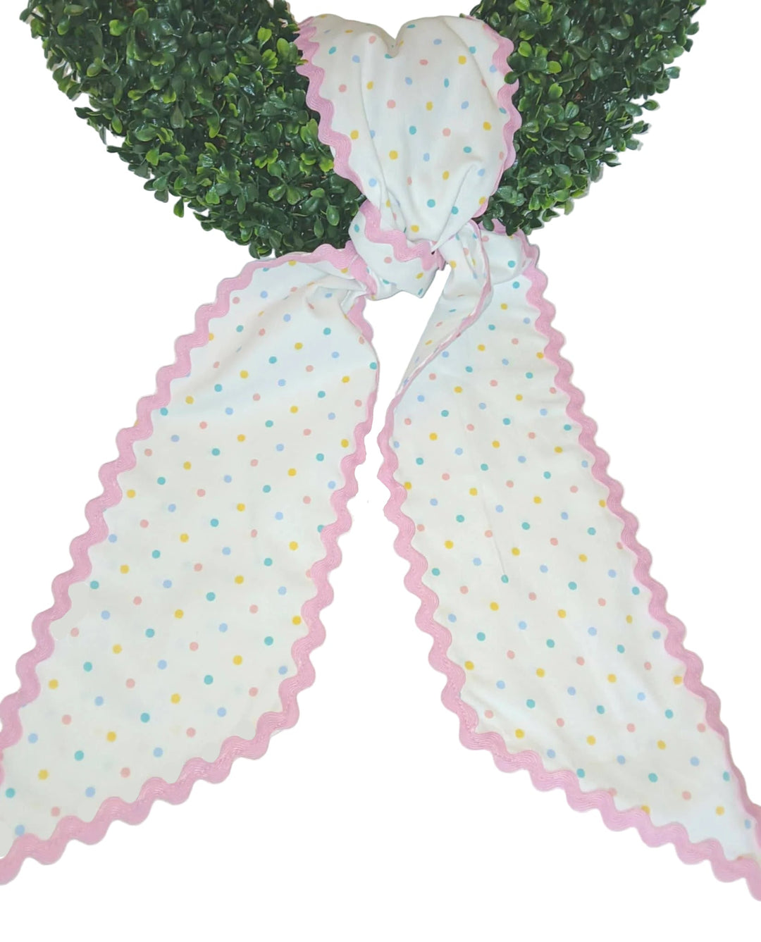 Decorative sash with polka dot pattern and pink scalloped edge on a white background.