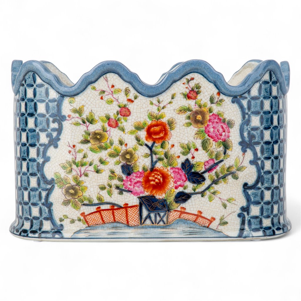 Decorative planter with floral design and scalloped edge on a white background