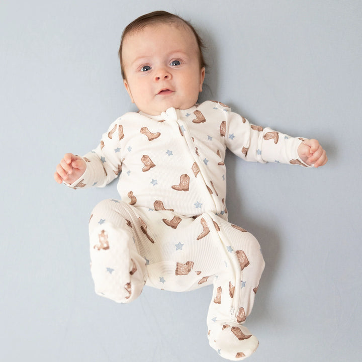 Angel Dear Mini Cowboy Boots 2-way Zipper Footie worn by a baby in a lifestyle view highlighting the mini cowboy boots 2-way design