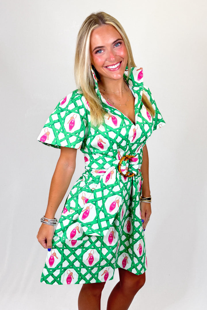 Woman wearing a green dress with pink floral pattern on a white background