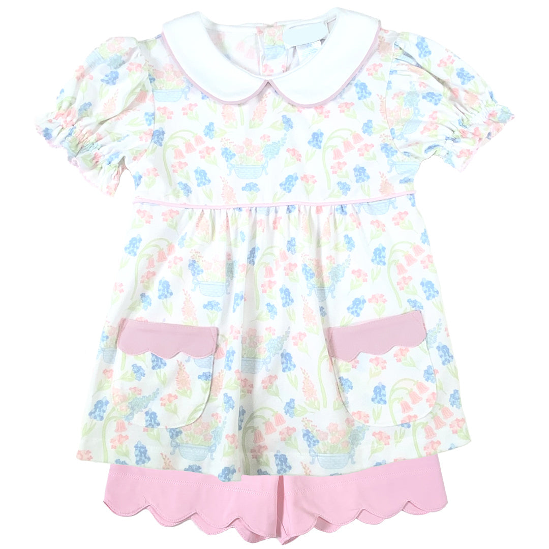 Children's top with floral pattern and pink accents and shorts on a white background