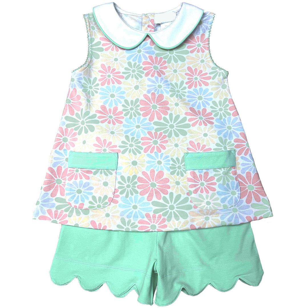 Children's top with floral pattern and green shorts on a white background