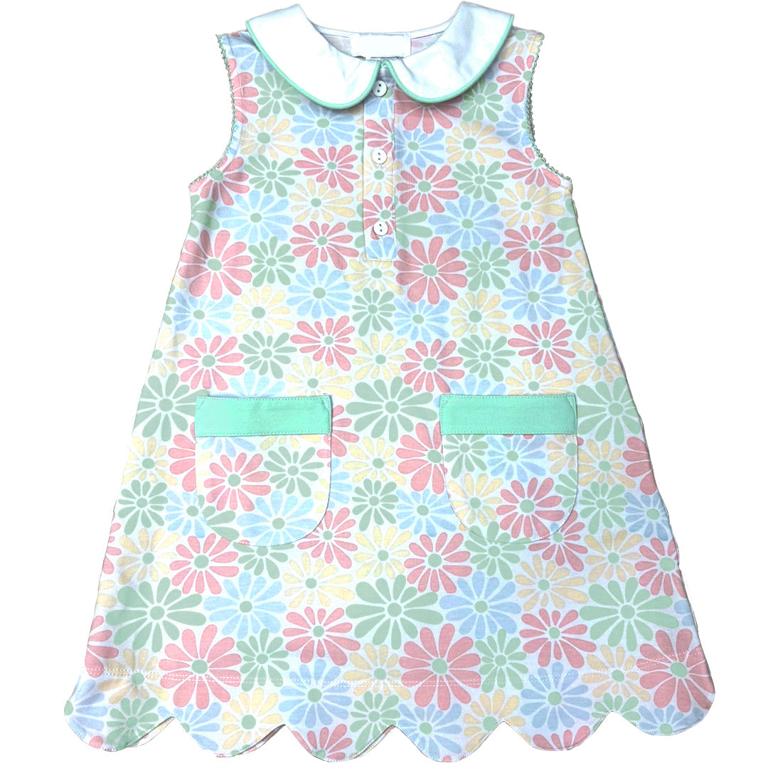 Children's dress with floral pattern and green accents on a white background