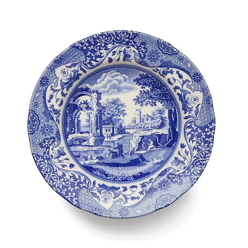 Blue and white decorative plate with scenic design on a white background