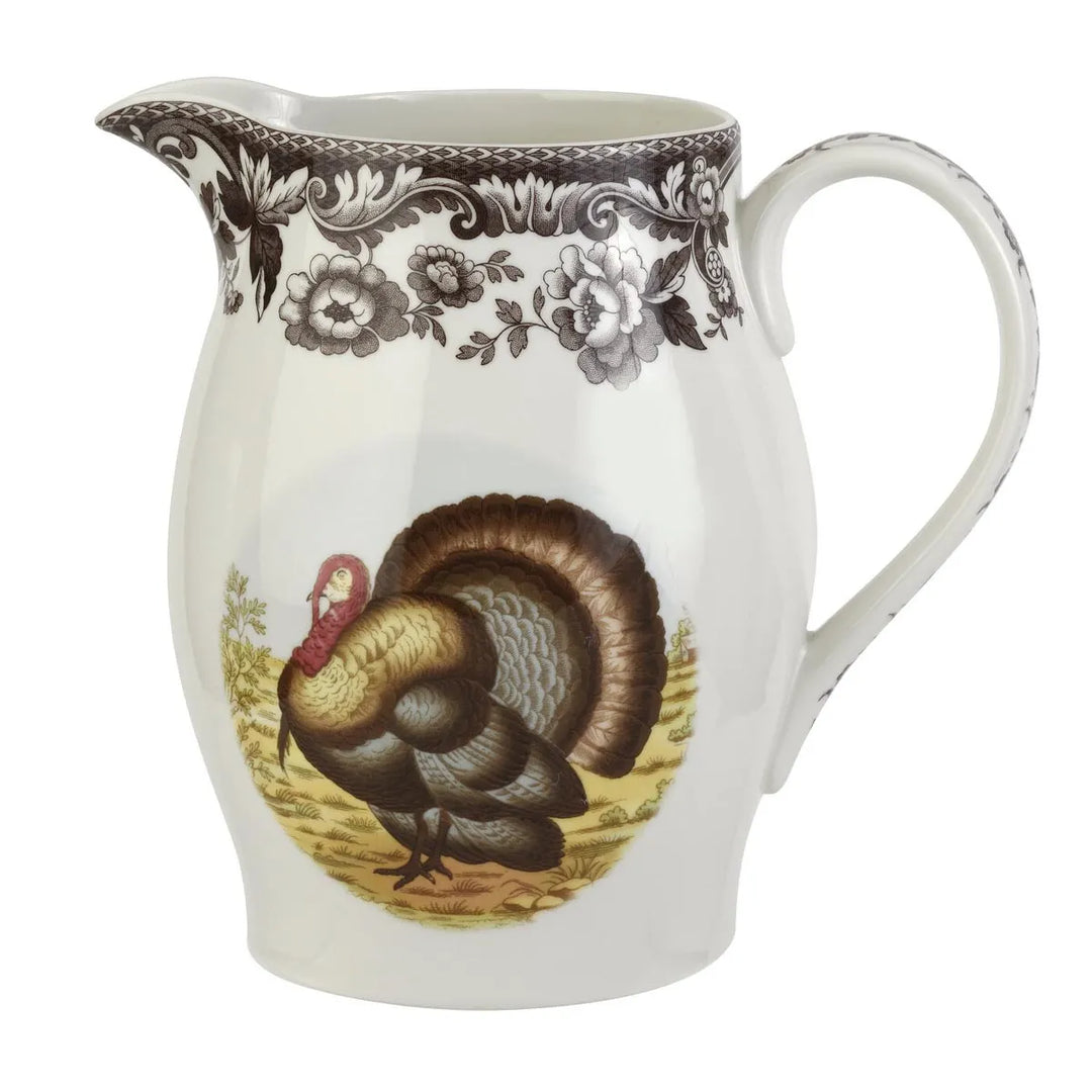 White ceramic pitcher with a decorative design of a turkey and floral patterns on a white background