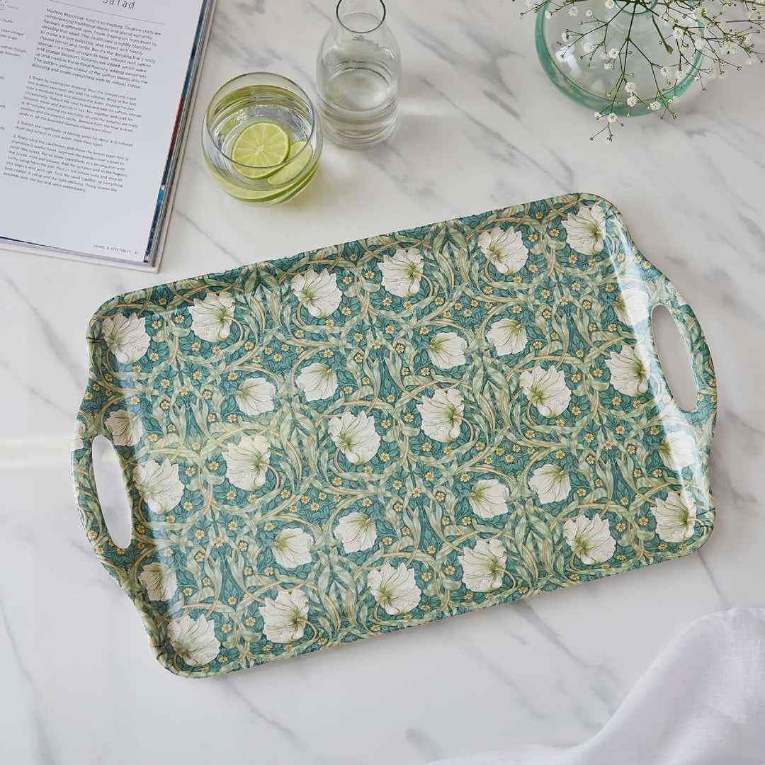 Floral patterned tray on a marble surface with glasses and a book.