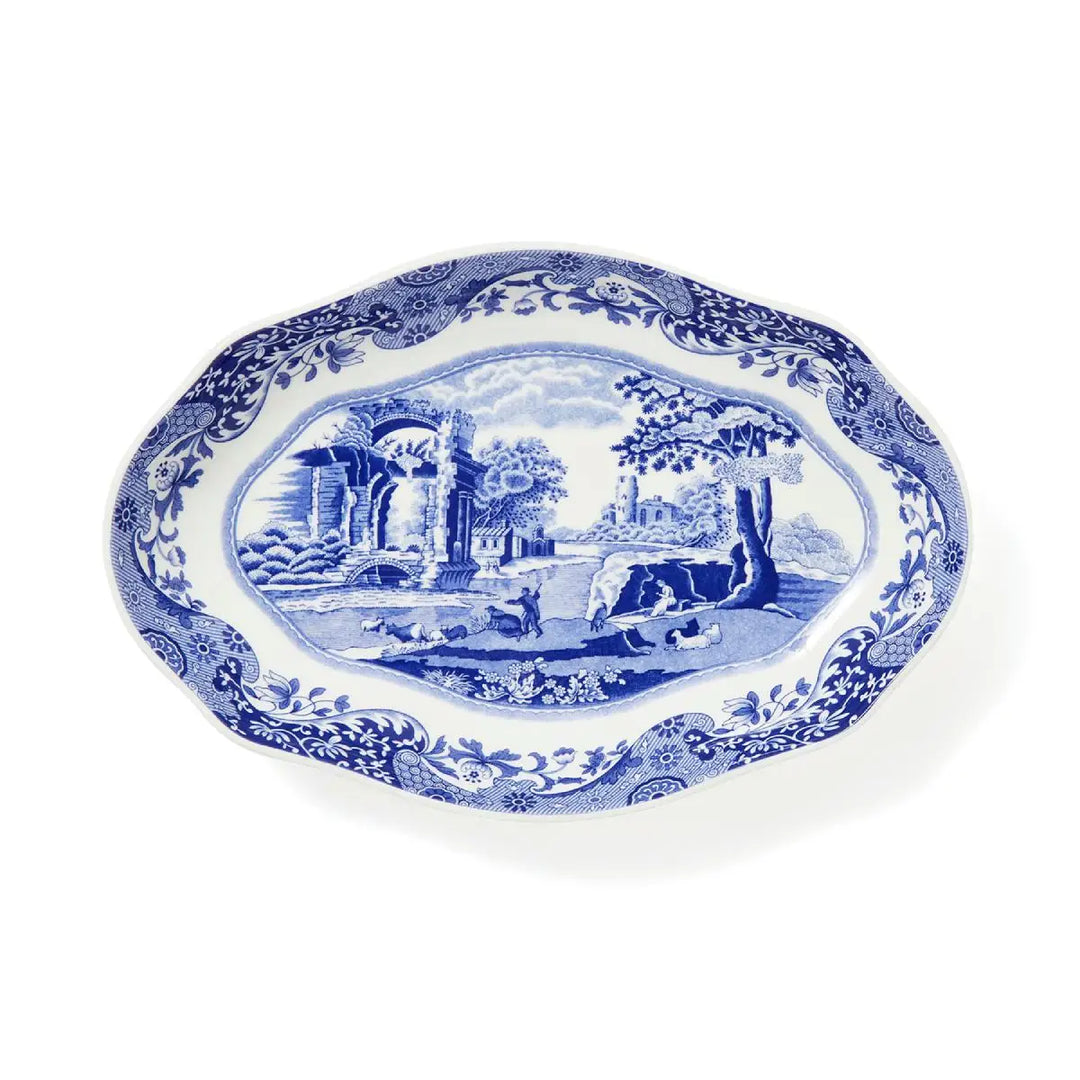 Blue and white decorative platter with scenic design on a white background