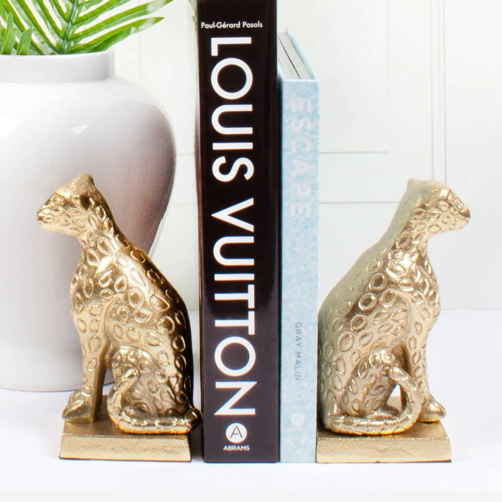 pair of golden leopard bookends holding book