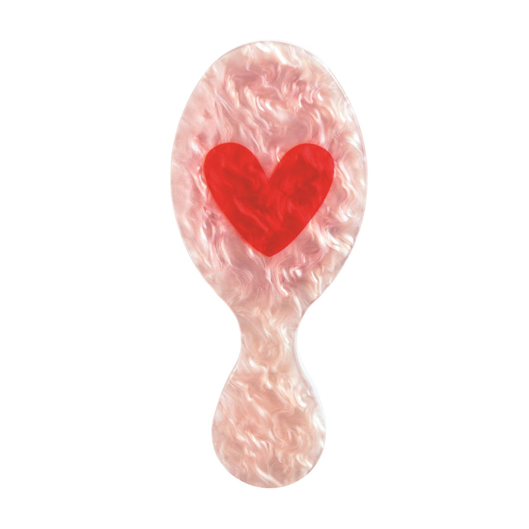 PINK HAIR BRUSH ON WHITE BACKGROUND WITH RED HEART ON BRUSH