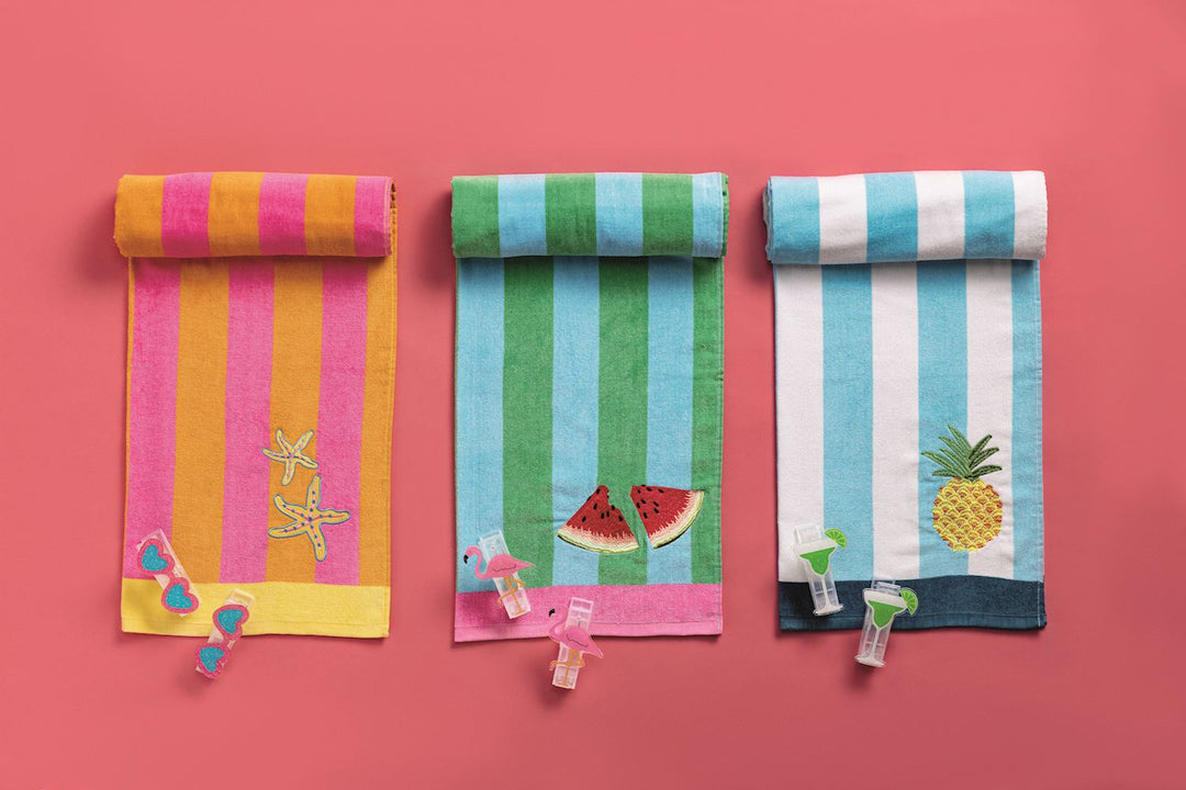THREE STRIPED COLORFUL TOWELS LAID OUT ON RED BACKGROUND