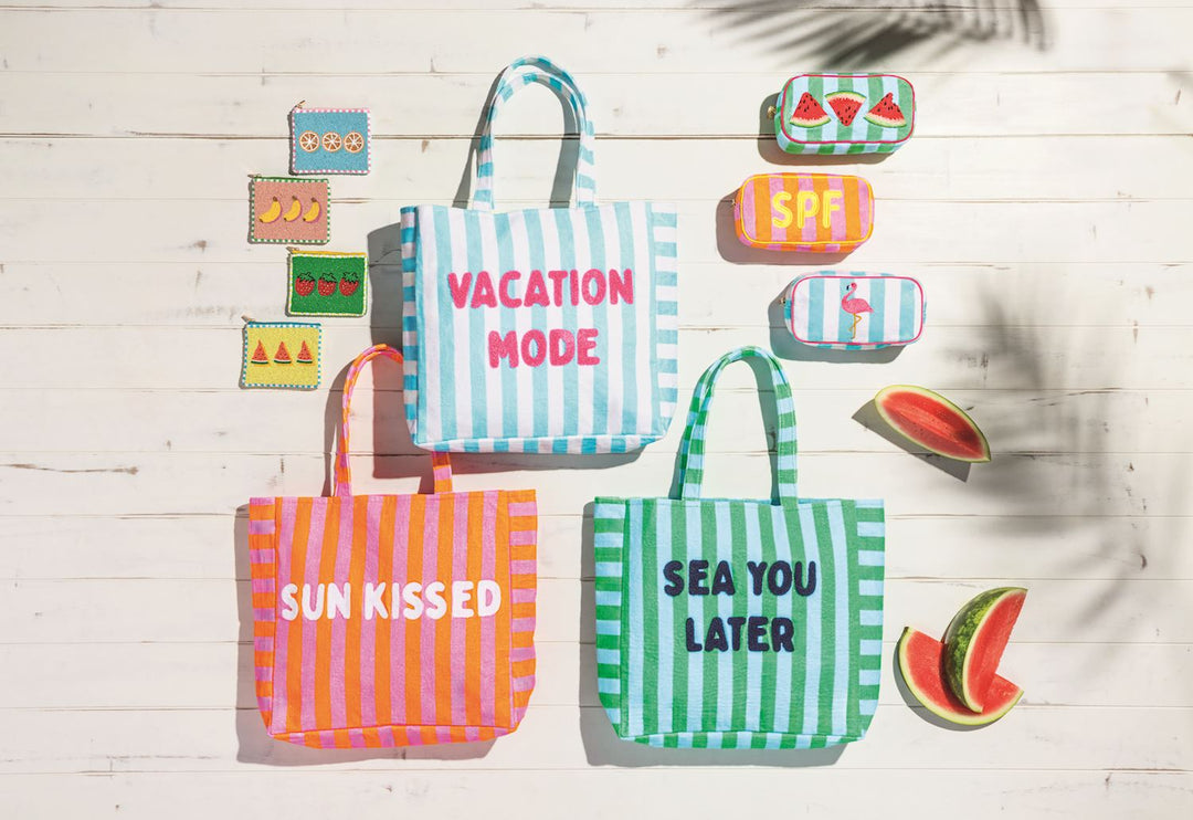 Set of colorful tote bags with text and small decorative items on a light wooden background