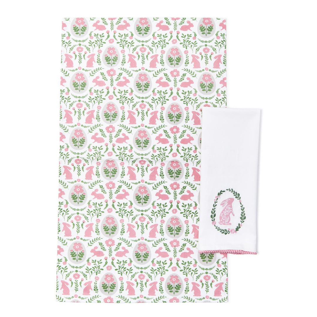 Floral and animal patterned towel with a matching white towel featuring a logo on a white background