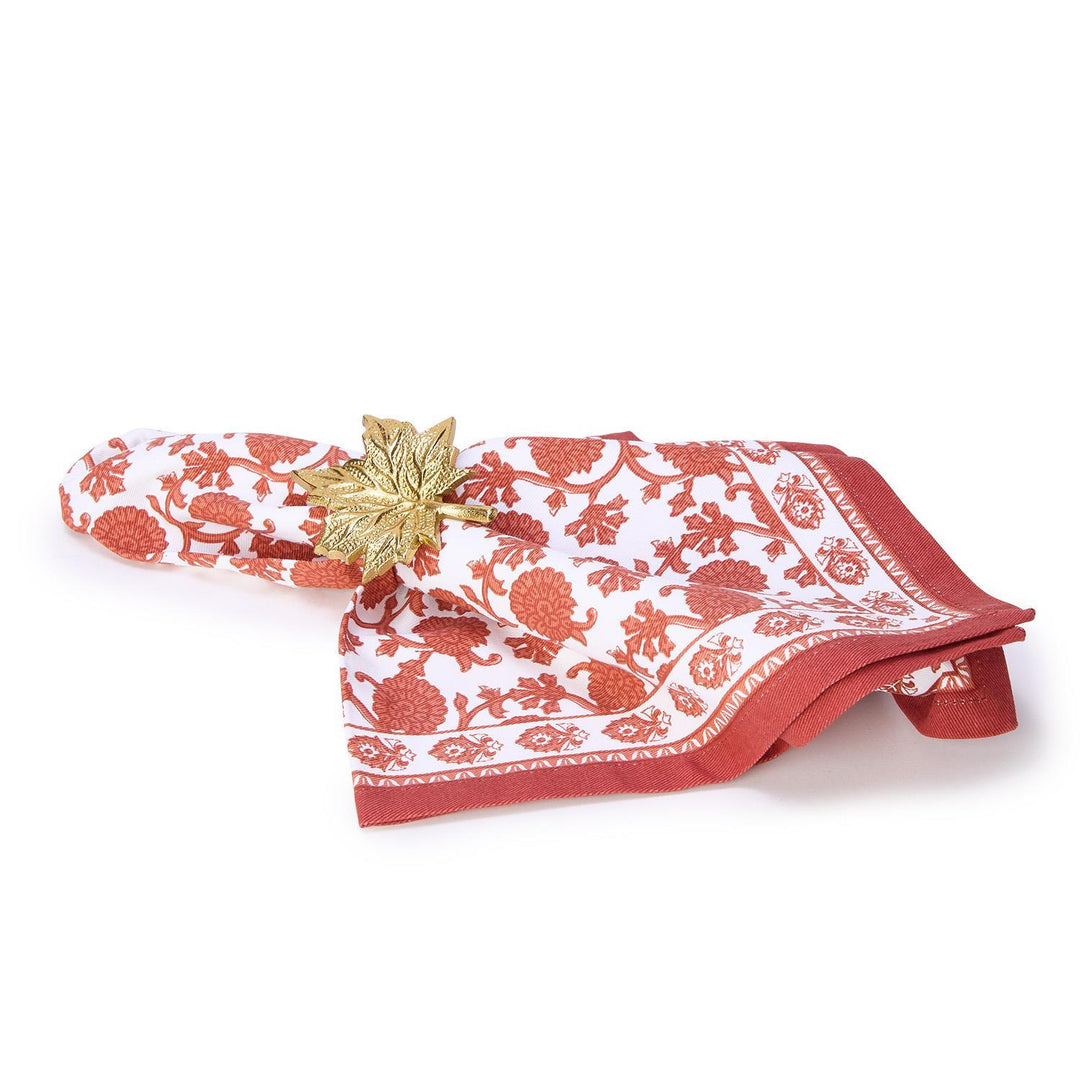 Red and white patterned napkin with a gold leaf on a white background
