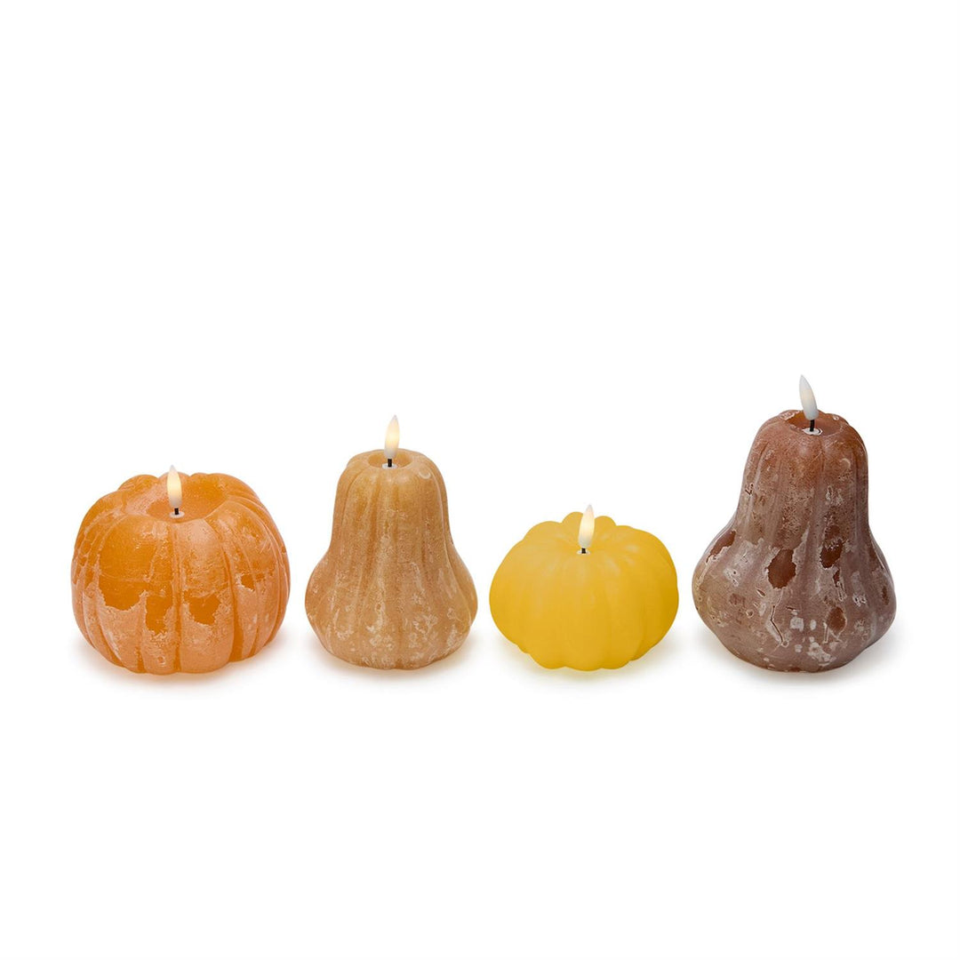Four pear-shaped candles in different colors on a white background