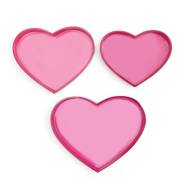 Three pink heart-shaped objects on a white background
