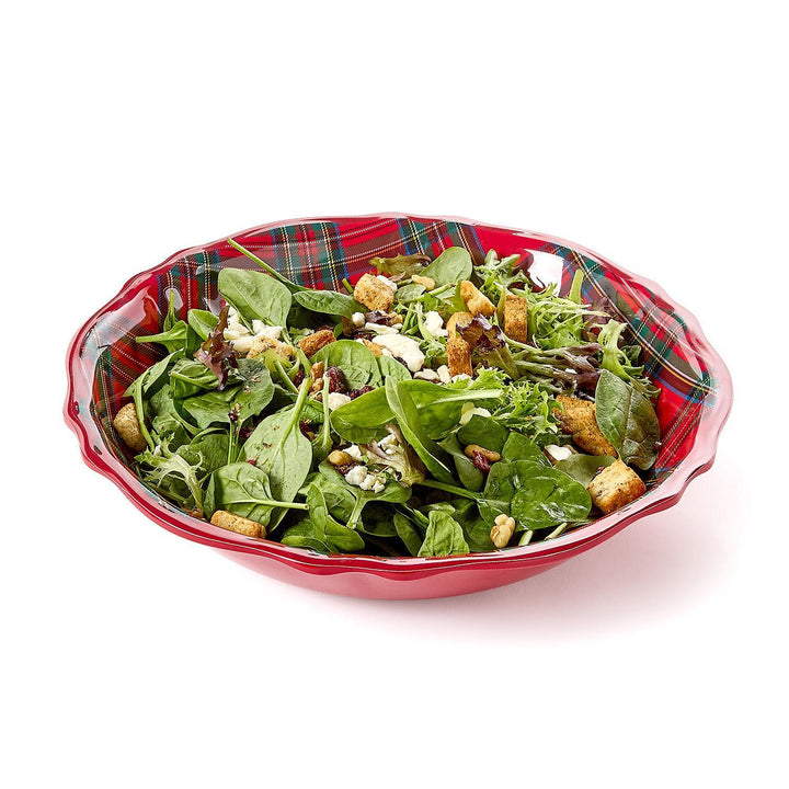 Plaid-patterned bowl filled with a green salad on a white background