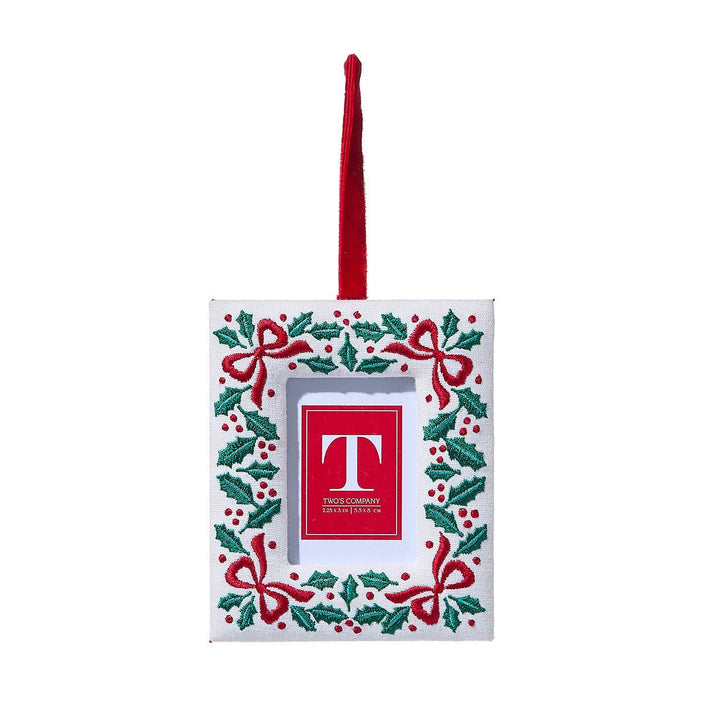Decorative Christmas frame ornament with red 'T' logo on a white background