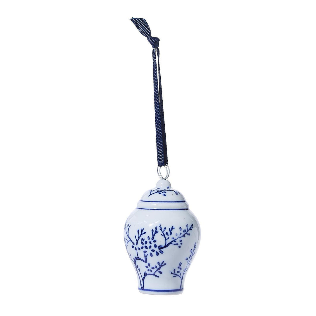 White ceramic ornament with blue floral patterns and a black strap on a white background