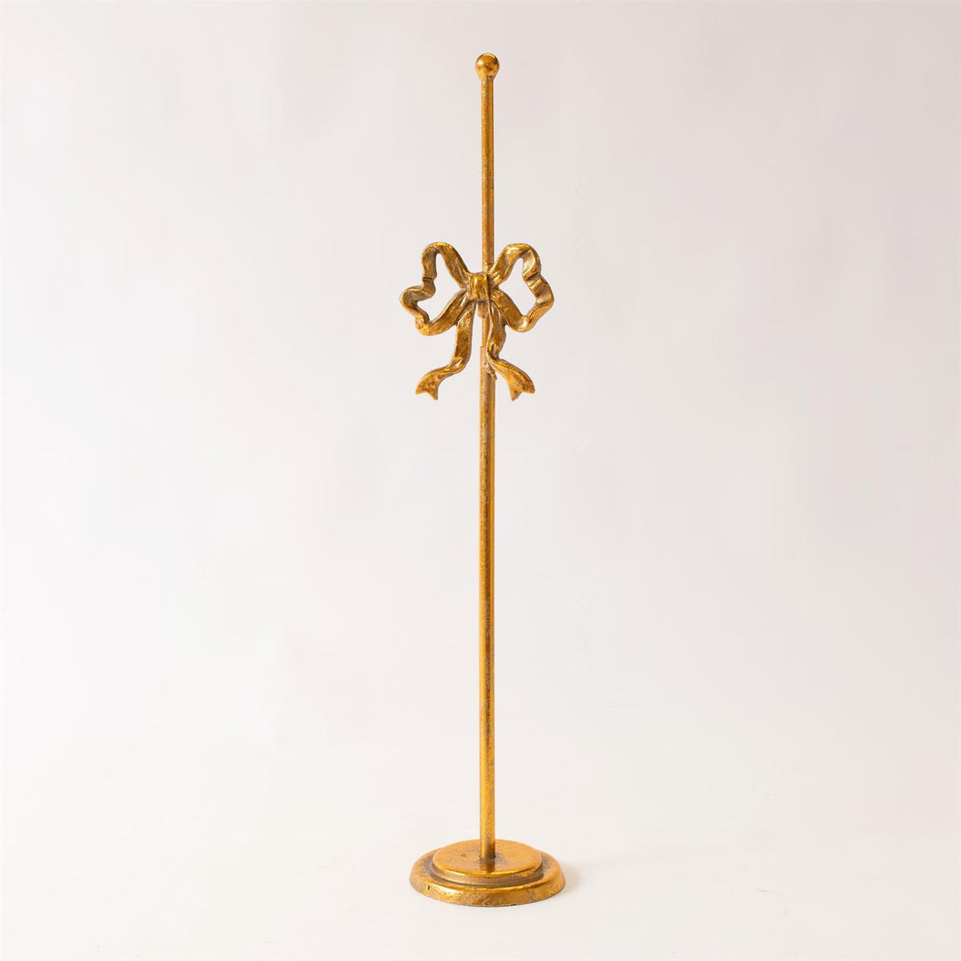 Gold decorative stand with a bow design on a white background