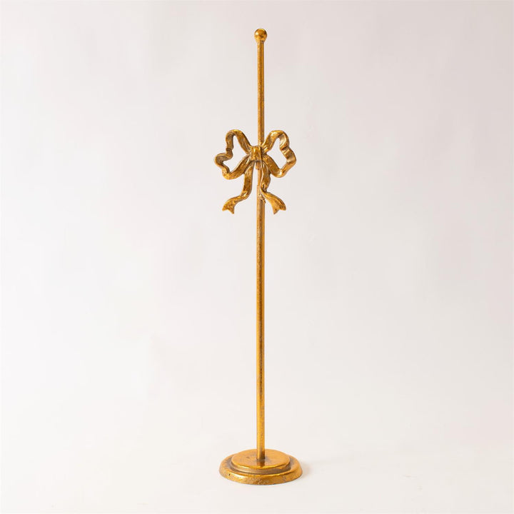 Gold decorative stand with a bow design on a white background