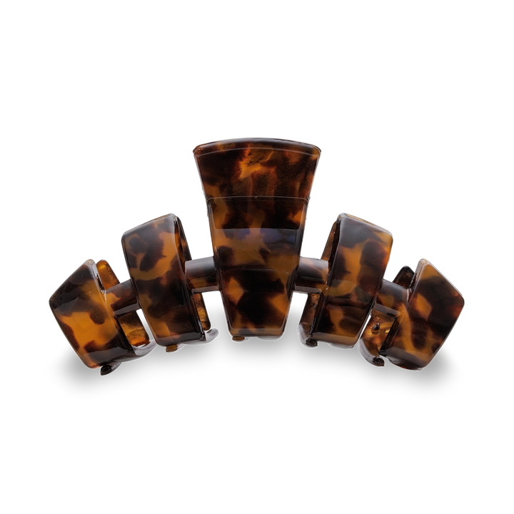 A tortoiseshell hair claw clip with a glossy amber-brown and black mottled pattern, shown on a clean white background.