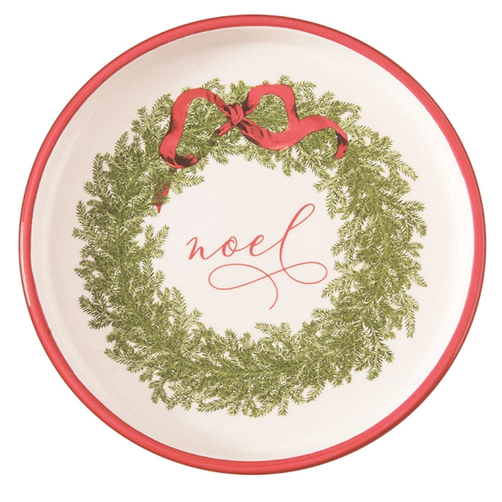 Round plate with a Christmas wreath design and 'noel' text on a white background