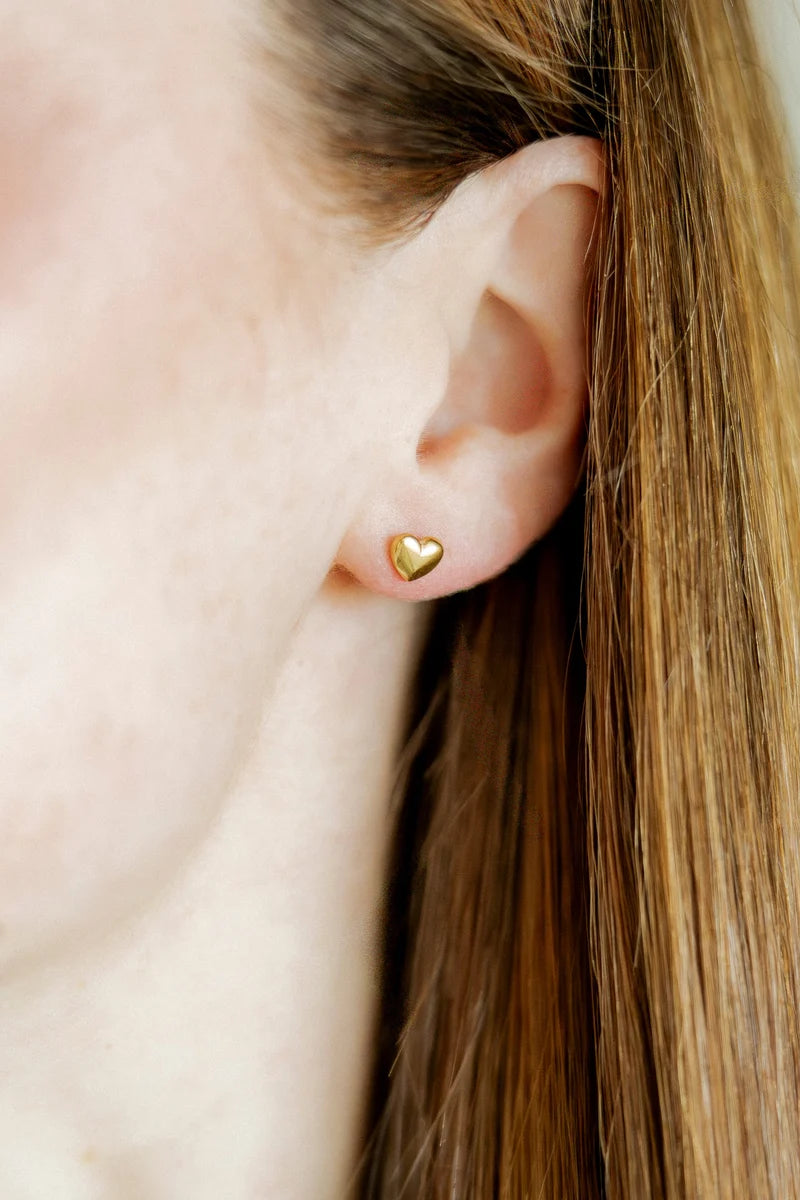Hadley gold heart screwback stud earring worn on the ear for a simple everyday look