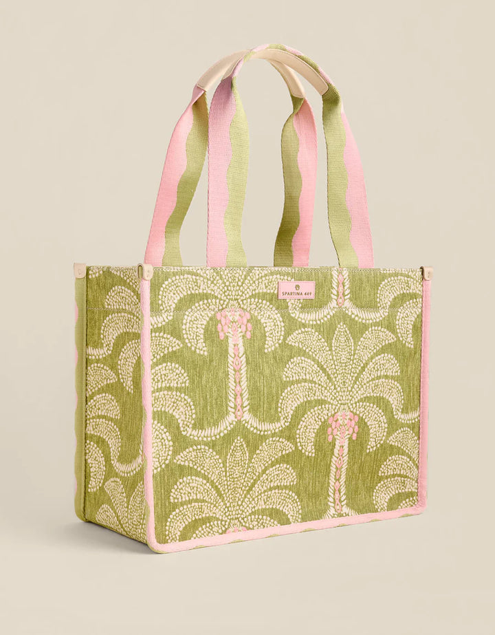 Green tote bag with pink handles on a beige background