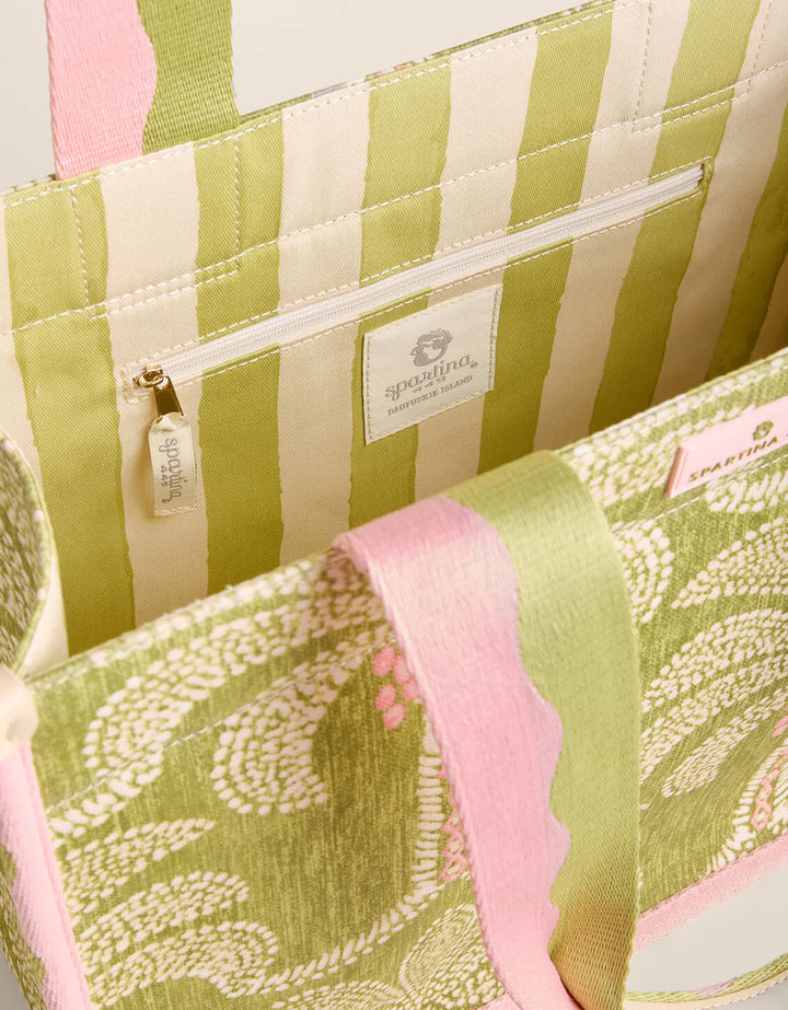 Close-up of a green and pink striped fabric with a brand label.