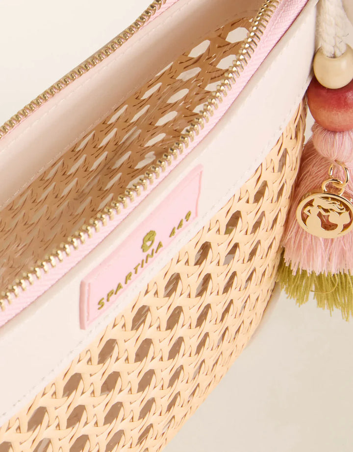 Close-up of a pink handbag with gold accents and a tassel detail.