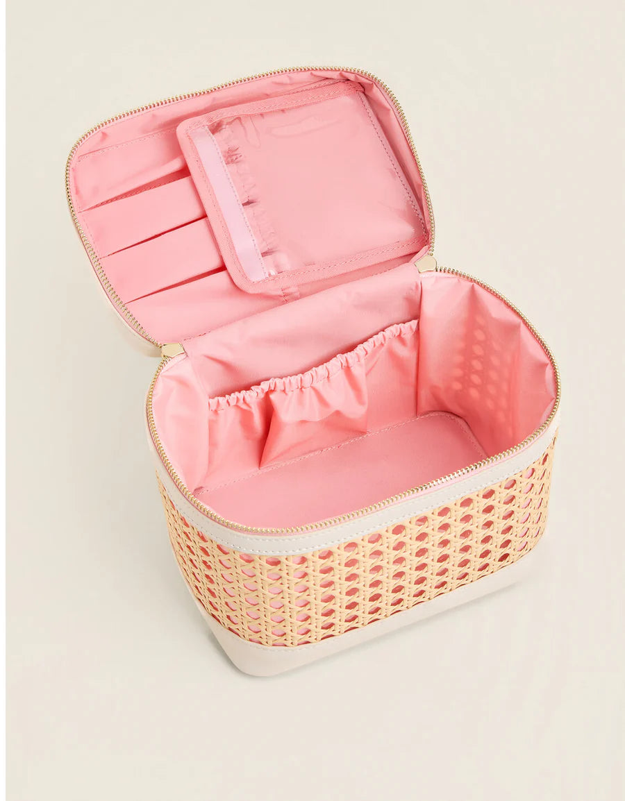 Pink wicker jewelry box with open lid on a light beige background