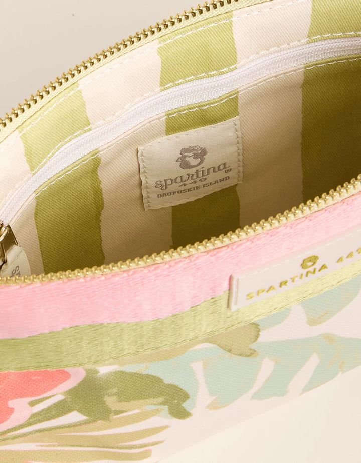 Close-up of a floral-patterned pouch with a brand label on a light background