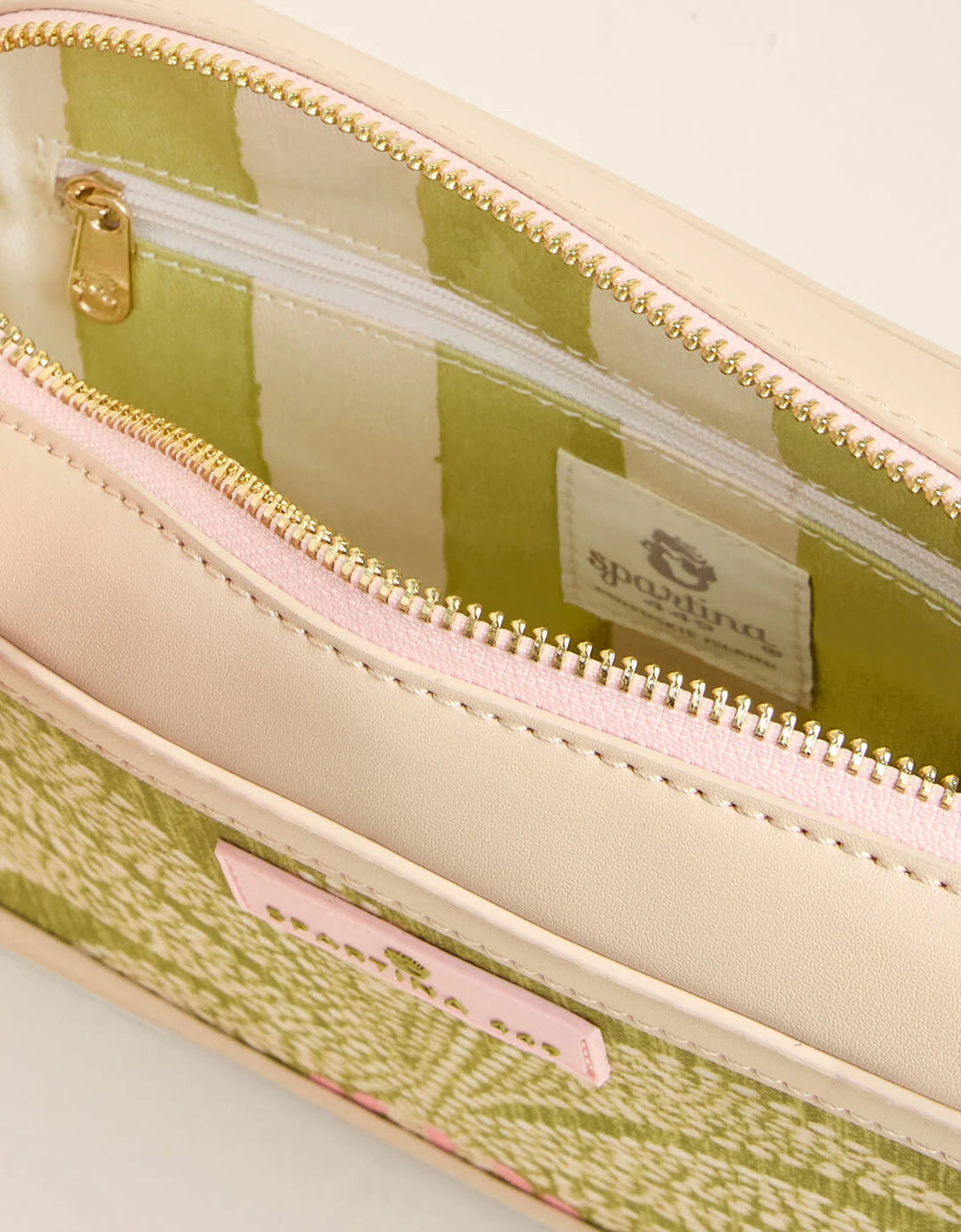 Close-up of a green and beige patterned pouch with a visible brand label.