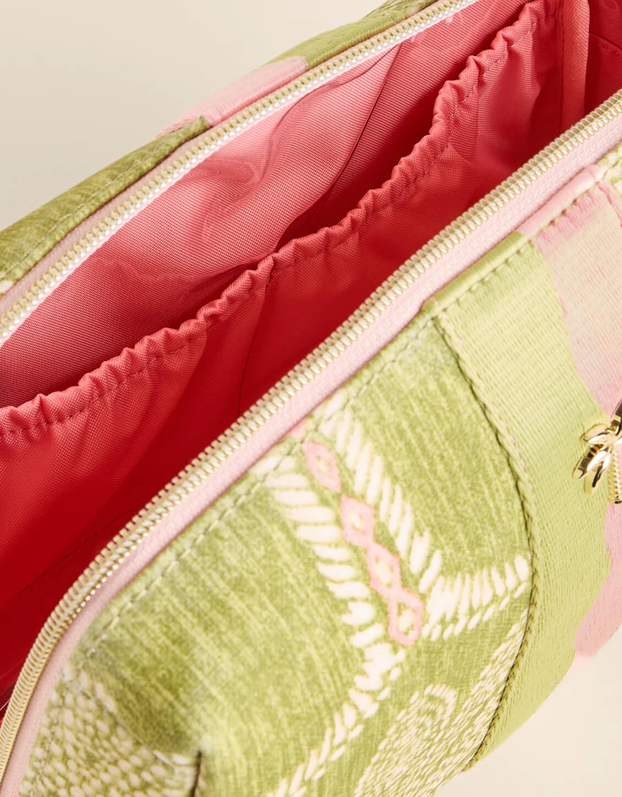 Close-up of a green embroidered pouch with pink interior