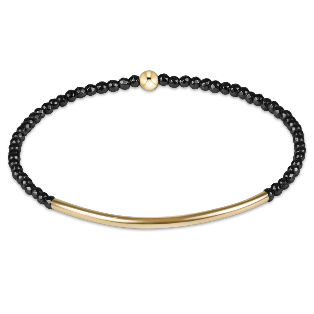 black beaded bracelet with gold bar on white background