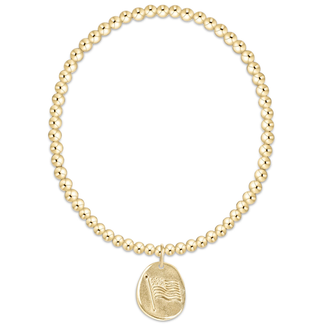 Gold beaded bracelet with a gold charm with flag on a white background