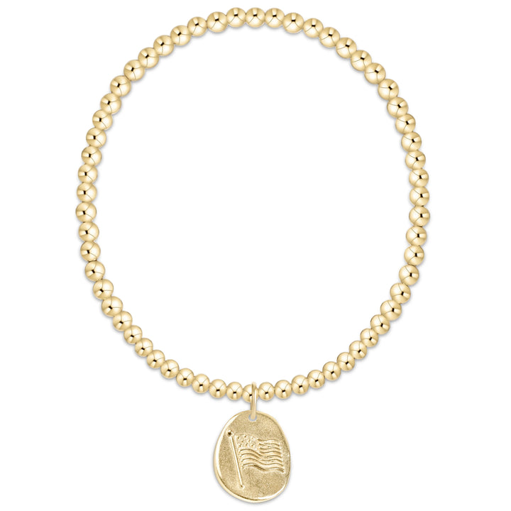 Gold beaded bracelet with a gold charm with flag on a white background