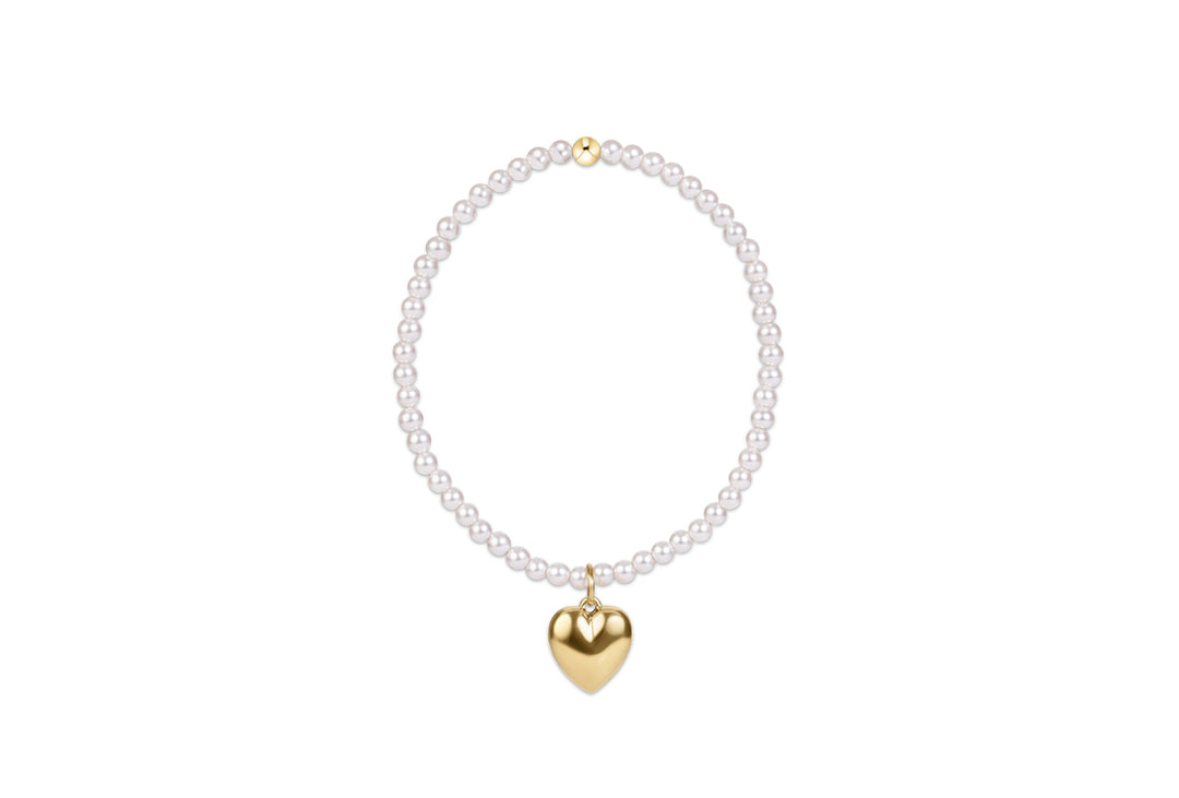A delicate pearl necklace with a polished gold heart pendant, displayed against a solid white background.