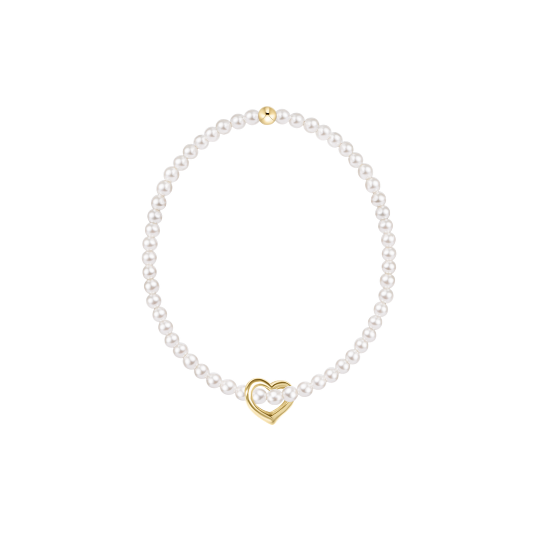 Pearl bracelet with a gold heart charm on a white background