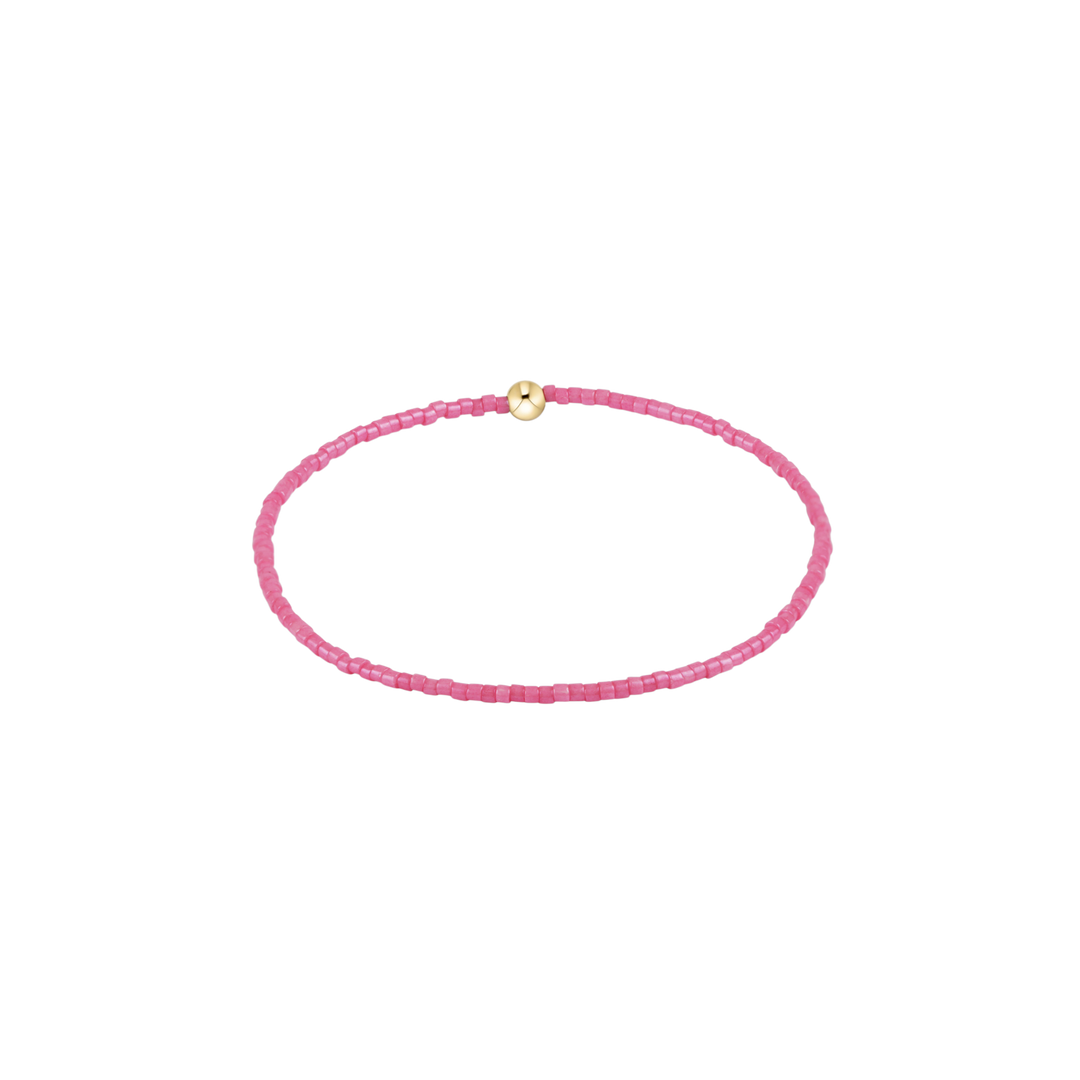 Pink beaded bracelet with a gold clasp on a white background