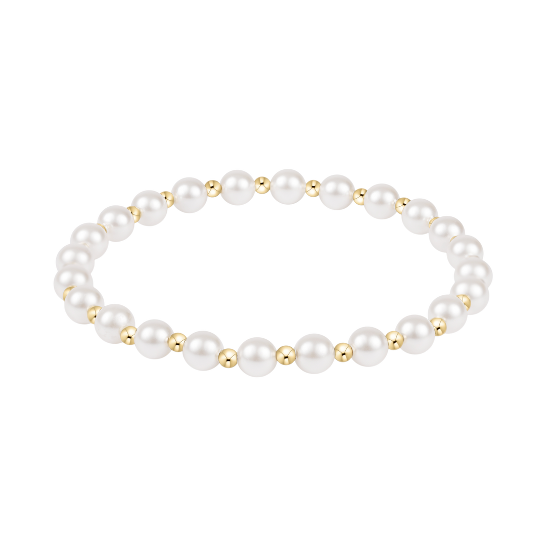 Pearl bracelet with gold accents on a white background
