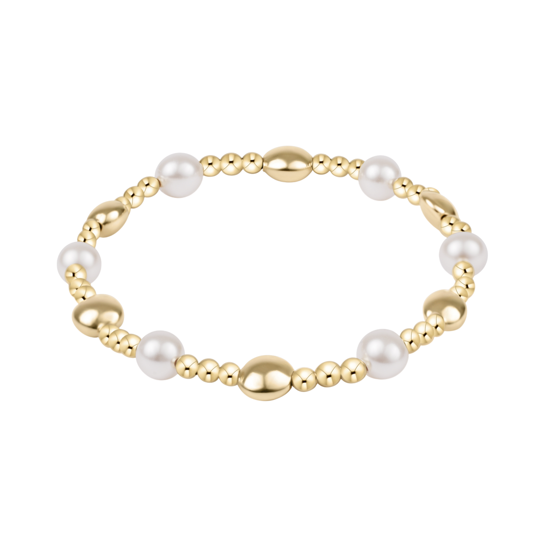 Gold and pearl bracelet on a white background